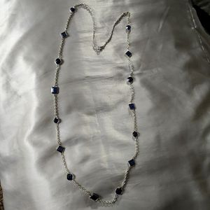 Long silver necklace with blue crystals.